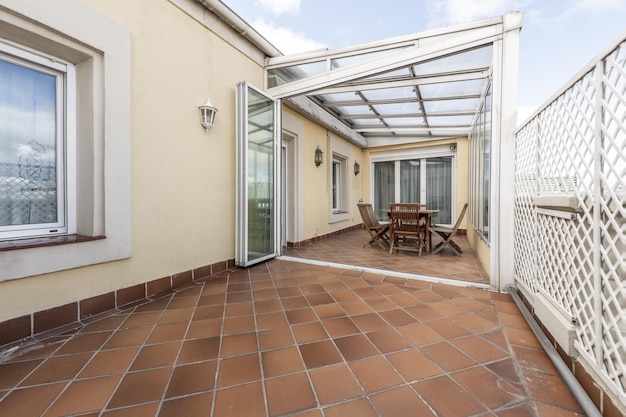 Penthouse terras met veranda en aluminium en glazen overkapping met een teakhouten eettafel