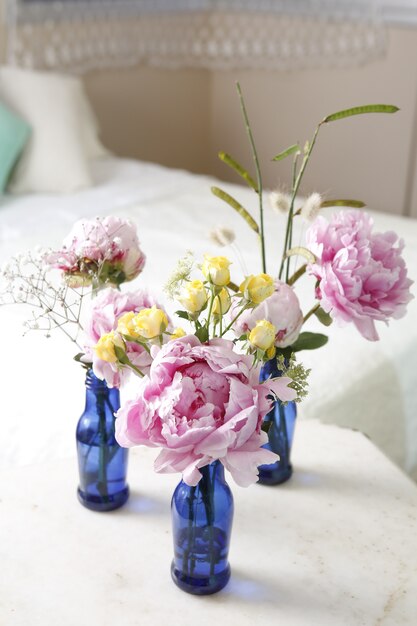 Peonies flower arrangement in glass vase on the table