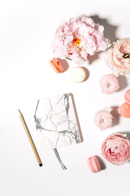 peonies flowers with macaroons on white background top view