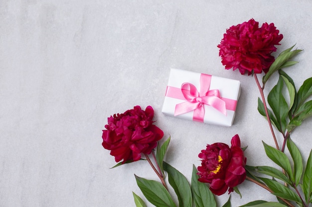 Peony flowers and a gift box composition. Flat lay, top view