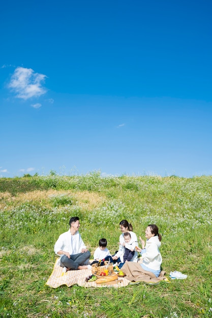 야외에서 피크닉을 즐기는 사람 (성인 3 명, 어린이 2 명)