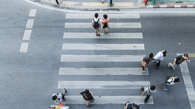 歩行者の歩行の道の上の眺めの横断歩道の向こう側の人々