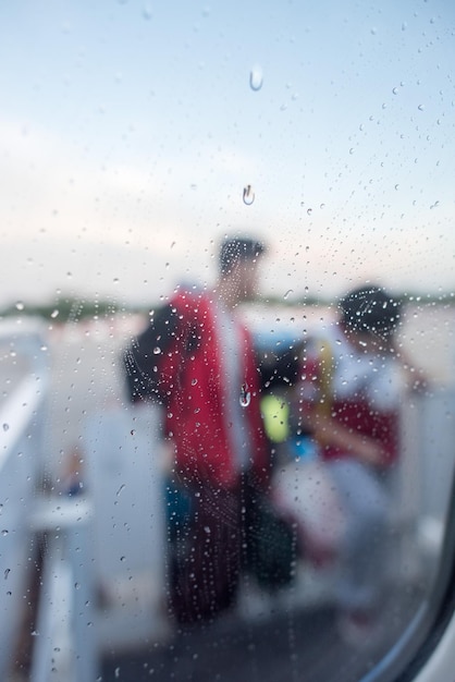People after airplane window on rainy day