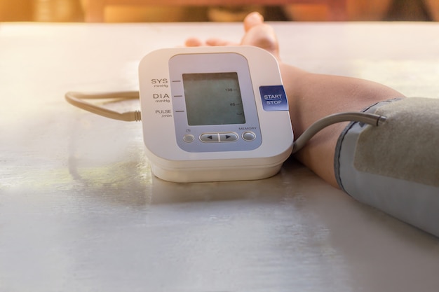 Le persone stanno controllando il monitor della pressione arteriosa e il cardiofrequenzimetro con la pressione digitale.