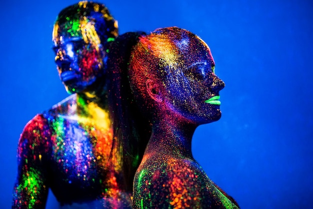 People are colored fluorescent powder. a pair of lovers dancing at a disco.