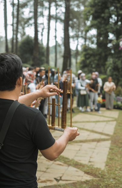 人々は、インドネシアの伝統的な楽器の 1 つであるアンクルンを演奏しています。