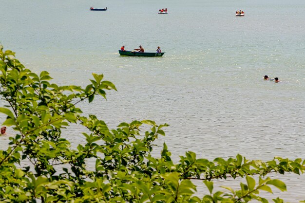 люди отдыхают на Черном море, катаются на лодках, отдыхают на берегу моря в летний сезон