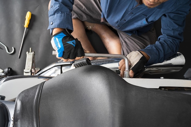 People are repairing a motorcycle Use a wrench and a screwdriver to work