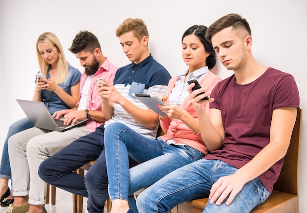 People are sitting in the lobby looking at the phones.