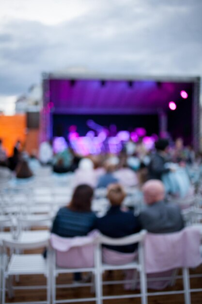 Foto la gente sta guardando un concerto di musica classica alla luce del giorno l'immagine sfocata dell'ambiente esterno