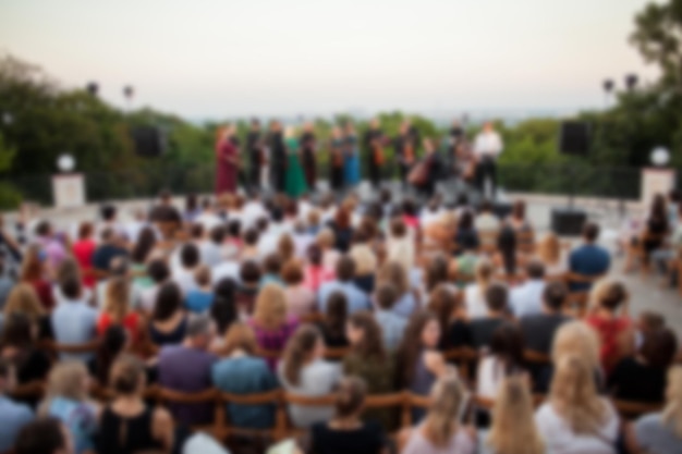 People are watching a concert of classical music in daylight outdoor enviroment blurred image