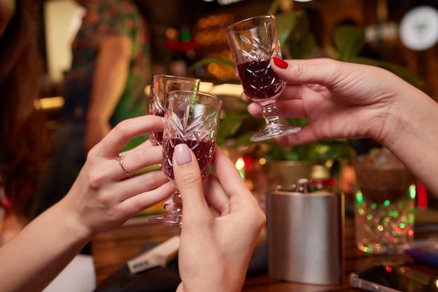 People at the bar try tinctures red tinctures in glasses alcoholic shots