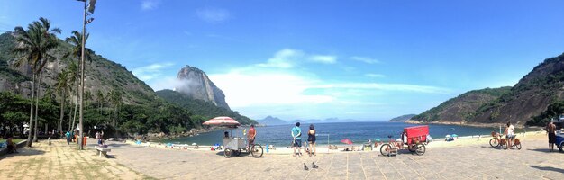 People at beach against blue sky