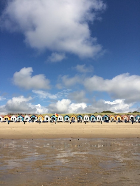 People on beach against blue sky