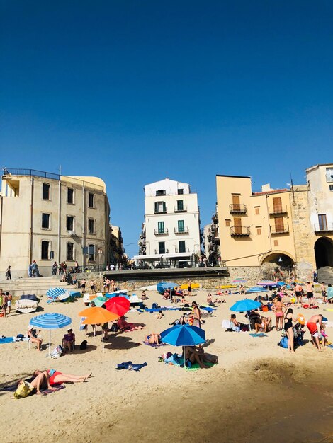 People on beach against blue sky