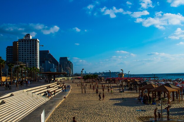 People on beach against buildings in city