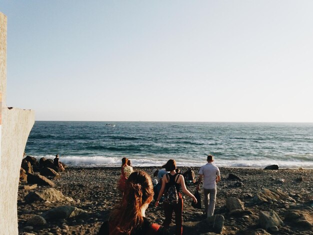 Photo people on beach against clear sky