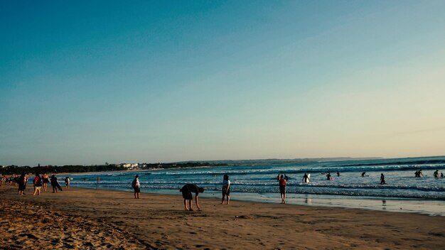 People on beach against clear sky