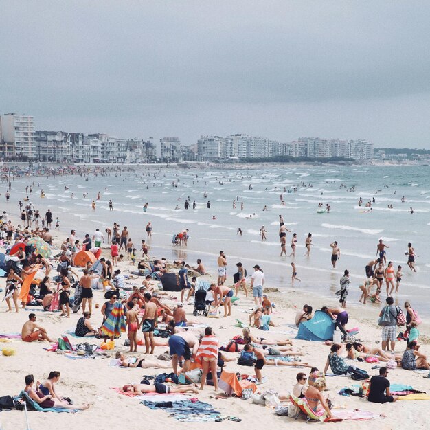 Photo people at beach against sky during summer