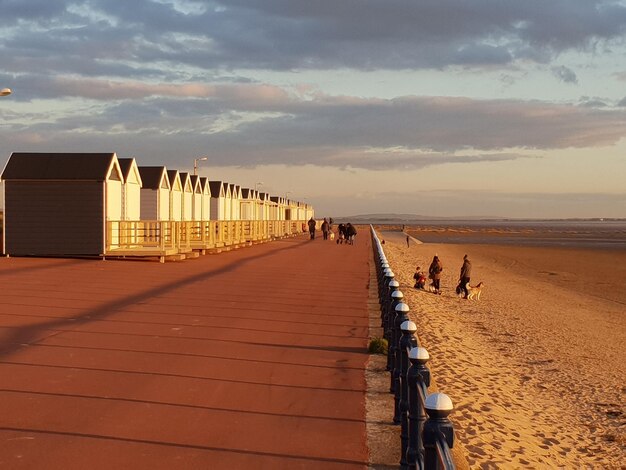 Foto gente sulla spiaggia contro il cielo durante il tramonto