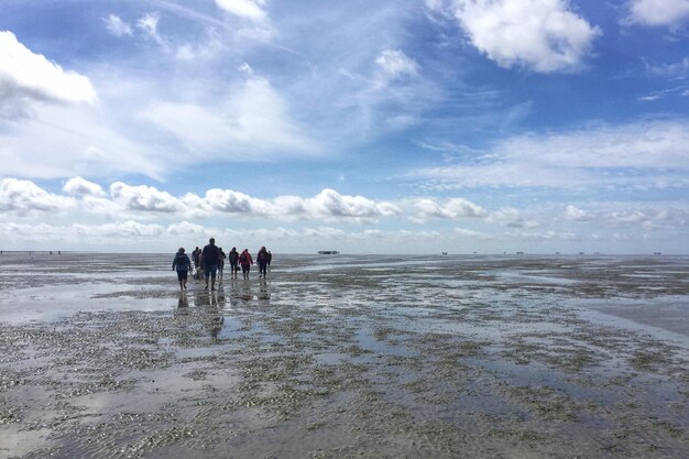 People at beach against sky