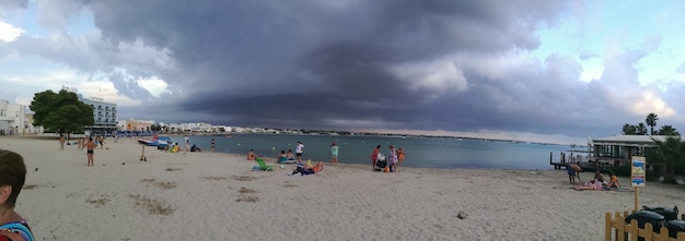 People at beach against sky