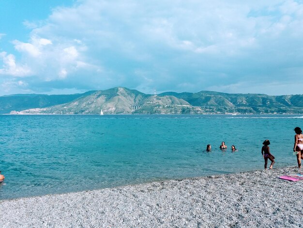 People on beach against sky