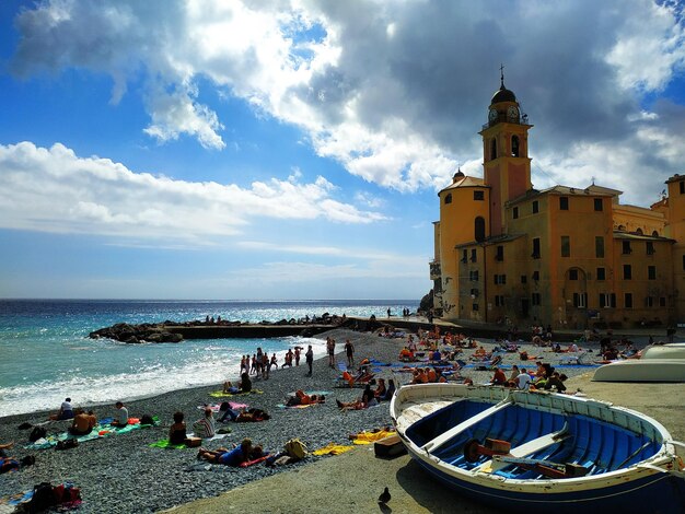 People on beach by sea against sky