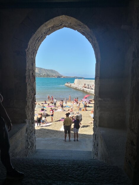 People on beach by sea against sky