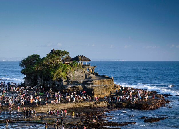 People on beach by sea against sky