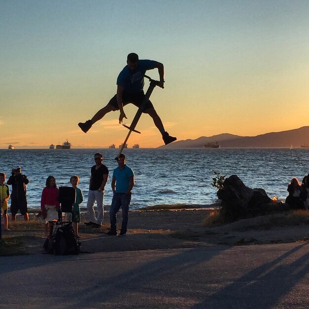 Photo people on beach at sunset