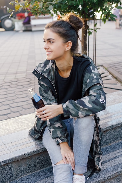 People, beauty, fashion, lifestyle and color concept - outdoor full body portrait of young beautiful happy smiling girl posing on street. model looking at camera. lady wearing stylish clothes