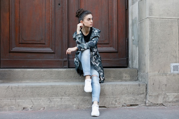 People, beauty, fashion, lifestyle and color concept - Outdoor full body portrait of young beautiful happy smiling girl posing on street. Model looking at camera. Lady wearing stylish clothes