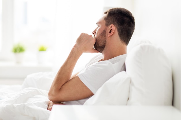 Photo people, bedtime and rest concept - stressed man in bed at home