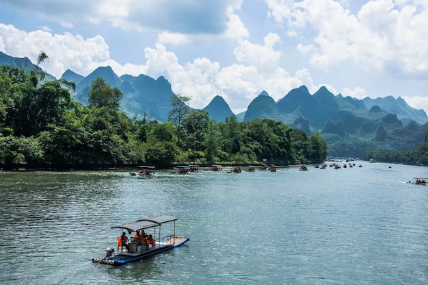 Photo people in boat sailing on river against mountains