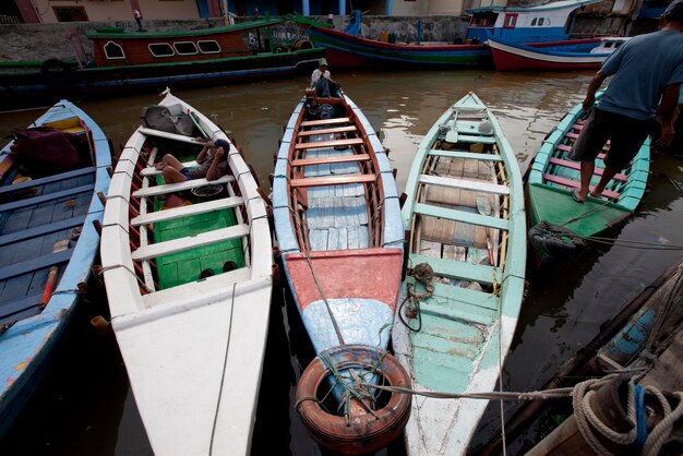 People in boats moored at canal