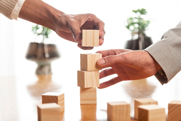 Photo people building piles of wooden cubes