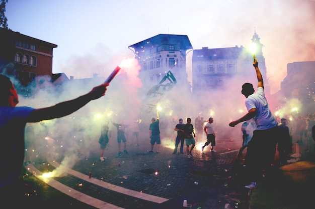 Foto gente che fa scoppiare fuochi d'artificio in strada