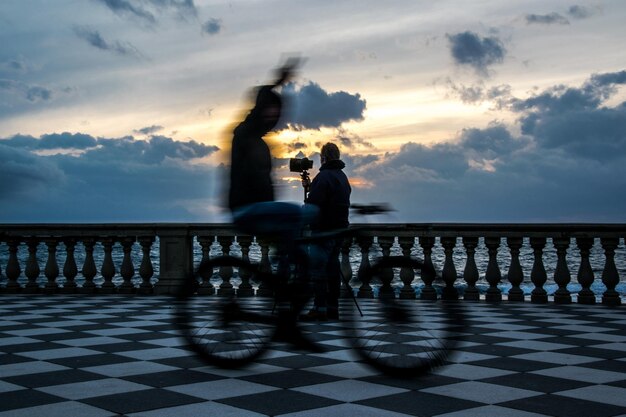 Foto gente sul mare contro il cielo durante il tramonto