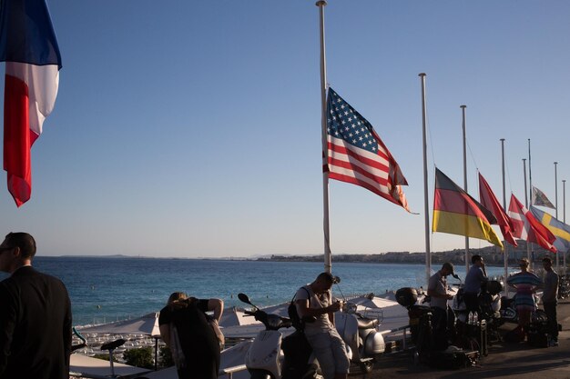 Photo people by various flags against sky