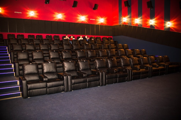 Photo people came to the cinema and sit in soft leather chairs. premiere, people go to the cinema