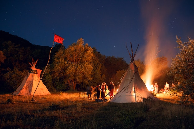 People camping in a forest at night