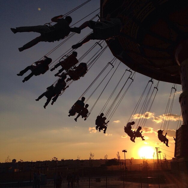 Foto gente in giostra al tramonto