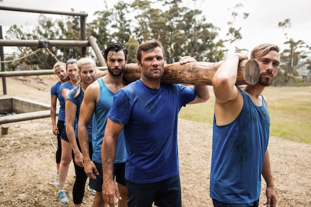 People carrying a heavy wooden log during boot camp