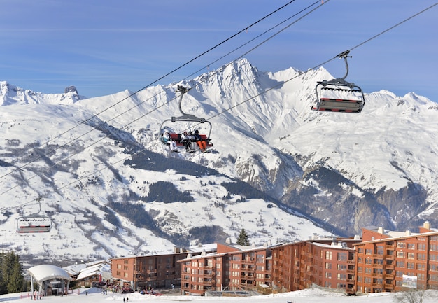 People on chair lift under blue sky