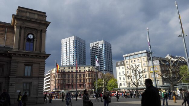 Photo people on city street against cloudy sky