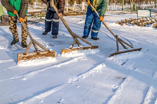 Photo people clean the road from snow with hand tools