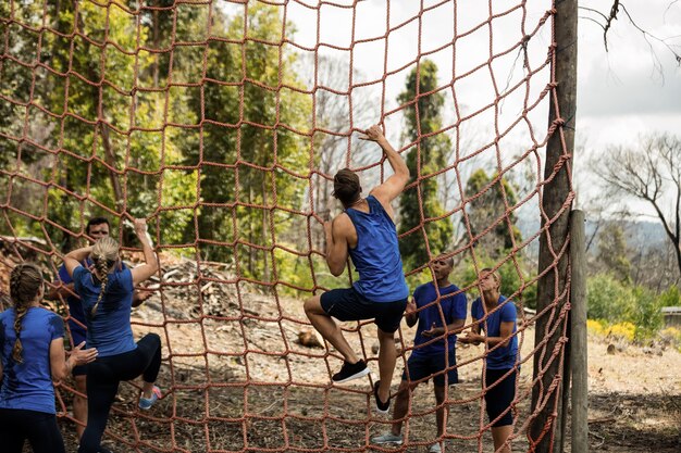 People climbing a net during obstacle course