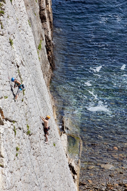 Photo people climbing together on an abrupt mountain