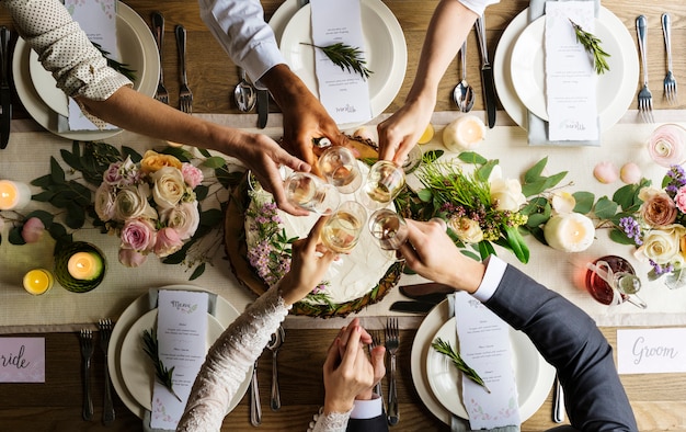 La gente aderisce ai vetri di vino sul ricevimento nuziale con la sposa e lo sposo